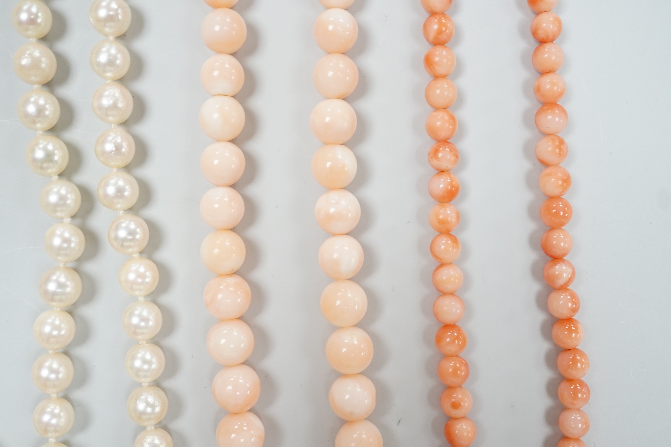 Two modern single strand cultured pearl necklaces, both with 375 clasp, one with hematite beads, longest 42cm, together with two modern coral bead necklaces, one with pair of matching drop earrings.